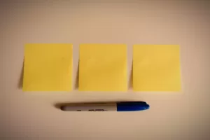 Rozpisywanie Candidate Journey Map - post-ity przyklejone na blacie z przygotowanym długopisem.